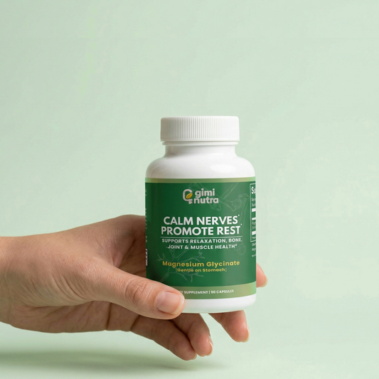 Hand holding a bottle of giminutra's magnesium glycinate with a green label on a light green background