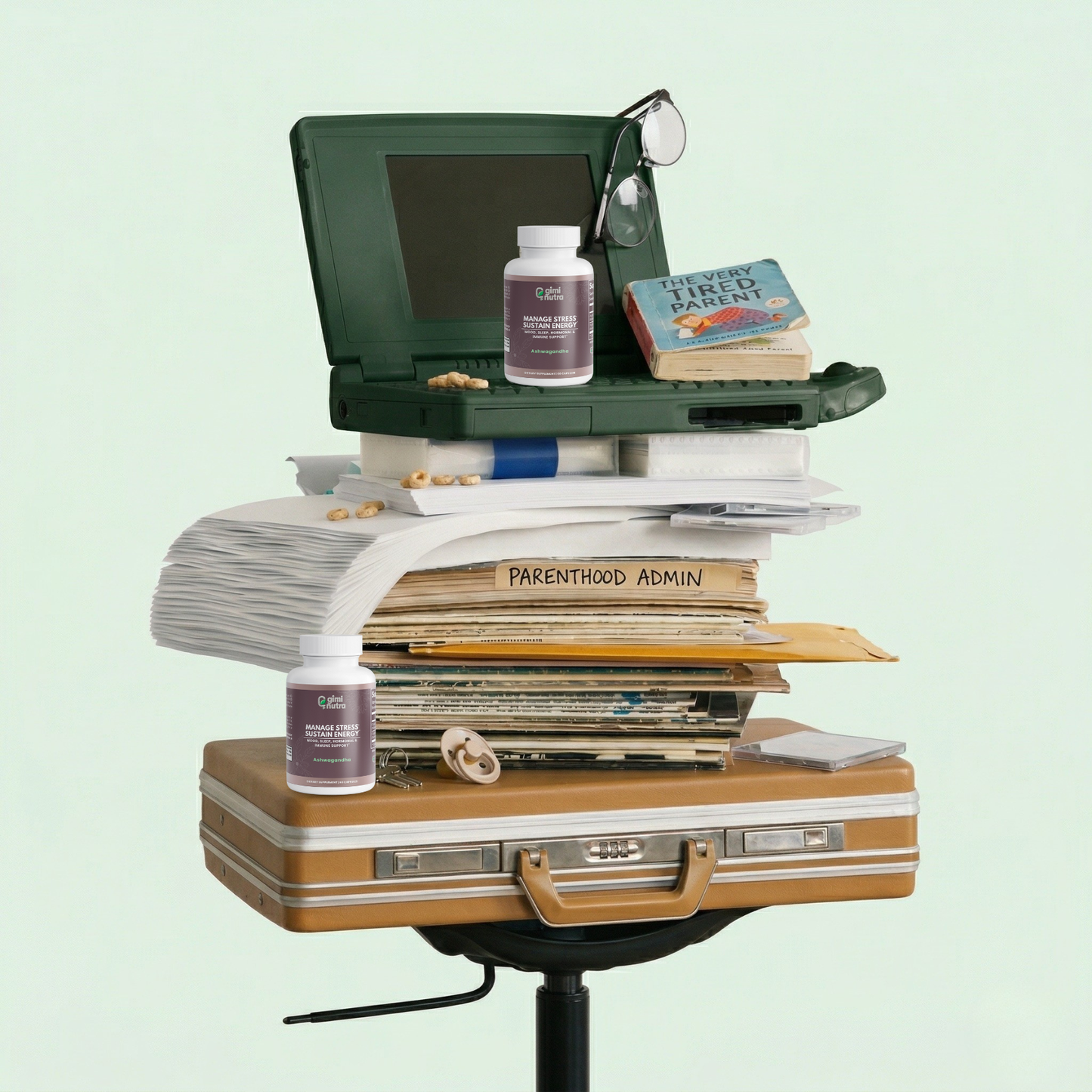 Stack of papers, suitcase, and green computer next to giminutra's ashwagandha bottles on a light green background. 