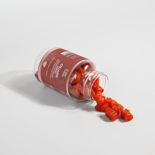 An opened bottle of Giminutra collagen gummies, with gummies spilling from bottle on a white surface and background